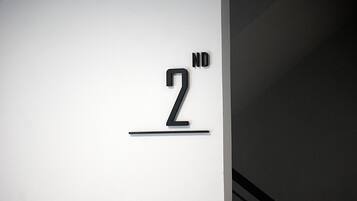 Een minimalistisch bord met het cijfer '2' en de letters 'ND' op een witte achtergrond.