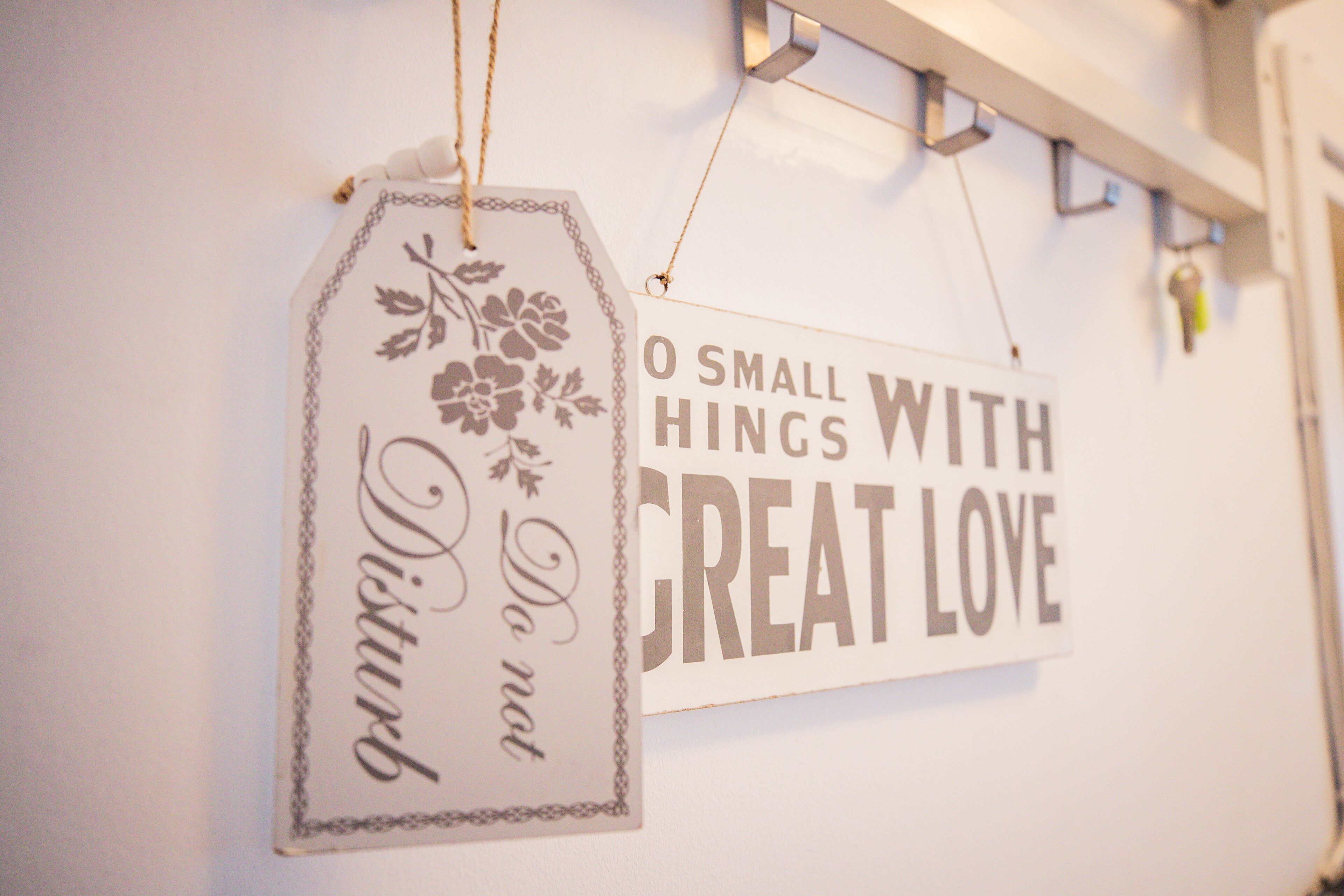 Two hanging signs with inspirational messages on a wall.
