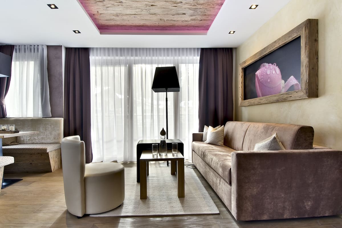 A modern living room with a sofa, armchair, coffee table, and floor lamp.