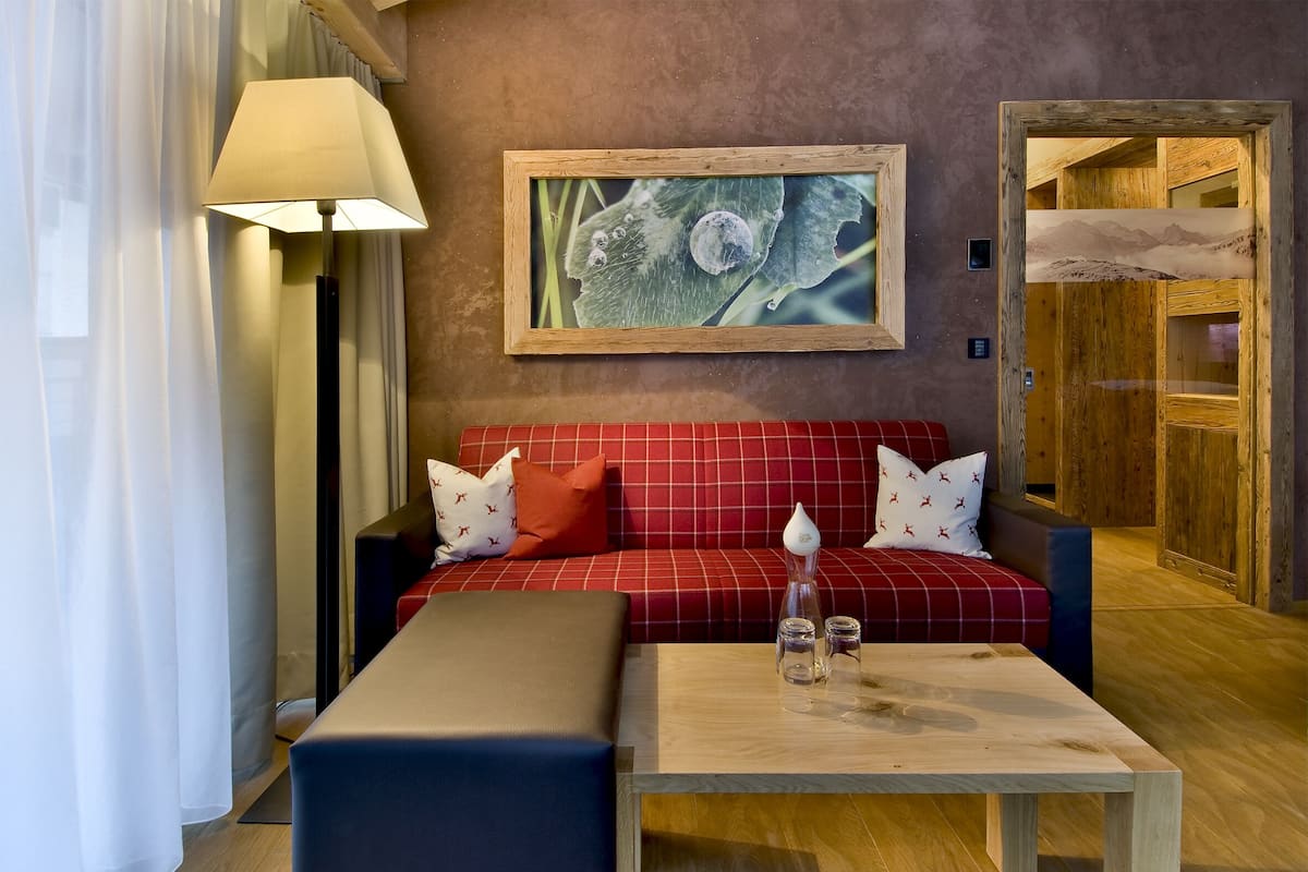 A room with a red sofa, a wooden coffee table, a lamp, and a framed picture on the wall.