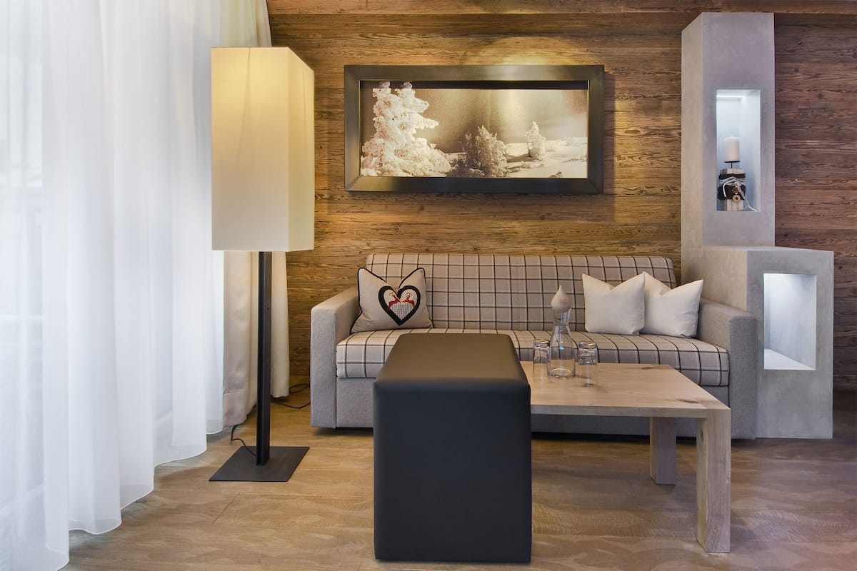 A modern living room with a sofa, a coffee table, and a wall-mounted picture frame.