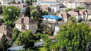 Zona residencial con casas, árboles y un edificio de techo azul.