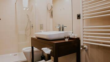 Un bagno moderno con una vasca, un lavabo con specchio e un porta asciugamani.