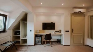 A room with a desk, chair, TV, and a door. - Hotel Republique (Sibiu)