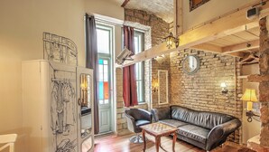 Een knusse woonkamer met een leren bank, een houten salontafel en een wandklok.