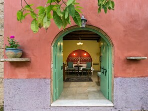Un arco de entrada a una habitación con una cama, una mesa y sillas.