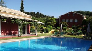A swimming pool with lounge chairs and a covered seating area. - Villa de Loulia Hotel (Corfu)