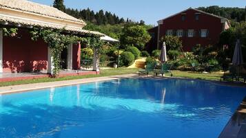 Een binnenzwembad, een buitenzwembad en parasols bij het zwembad