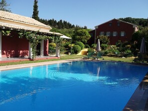 Una piscina techada, una piscina al aire libre, sombrillas