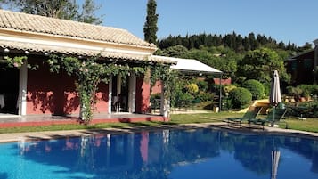 Alberca techada, alberca al aire libre y sombrillas en la alberca