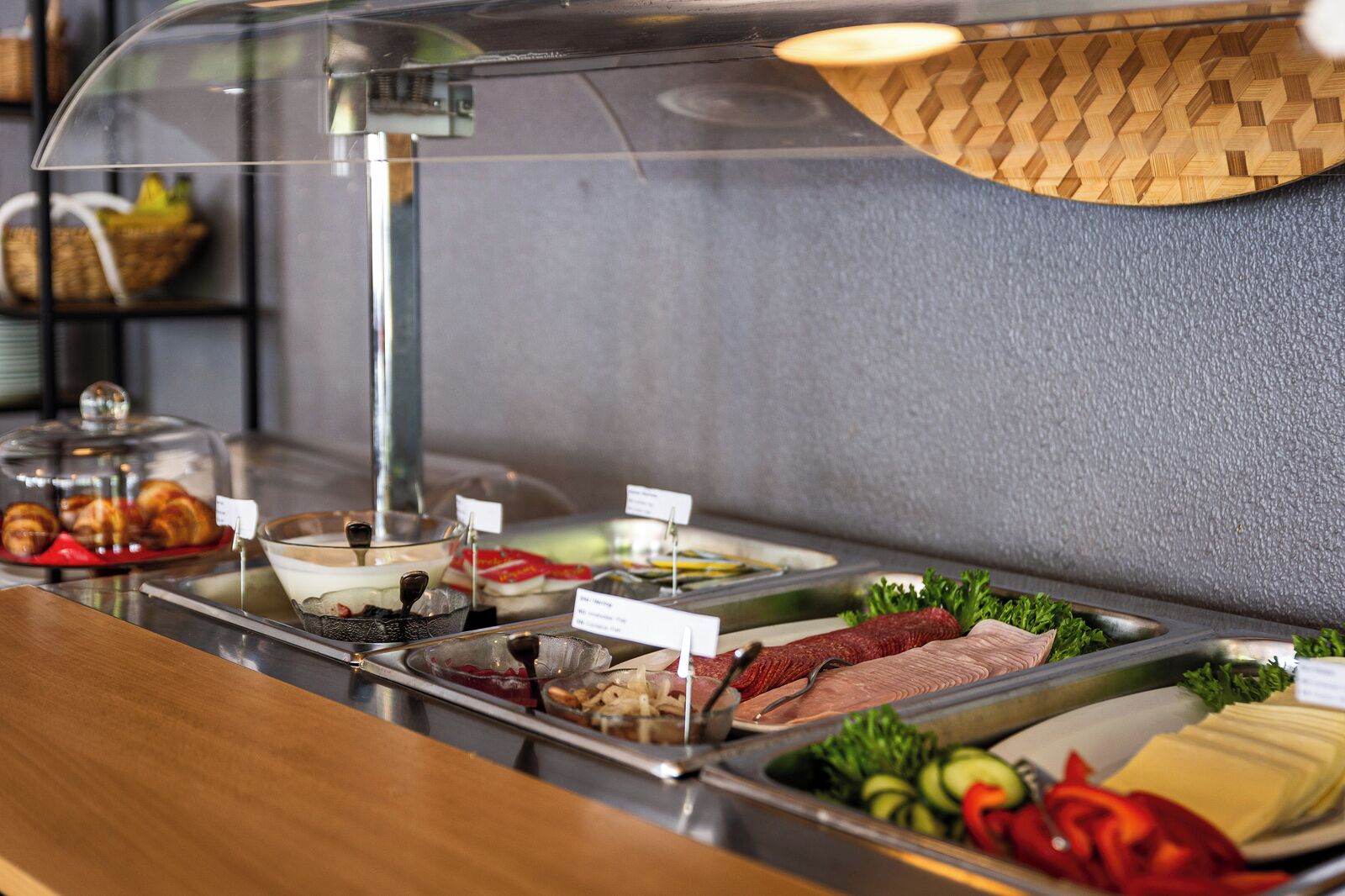 Ein reichhaltiges Buffet mit verschiedenen Speisen, darunter Fleisch, Käse und Gemüse.
