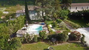 A residential property with a swimming pool, surrounded by lush greenery and a well-maintained garden. - Maison Bersane (Le Poujol-sur-Orb)