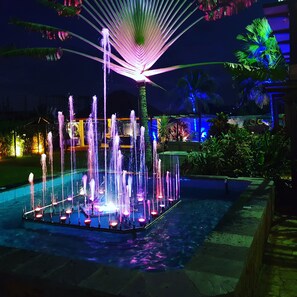 A nighttime fountain with multiple water jets and illuminated by colorful lights. - Sweet Garden Hotel (Kumasi)