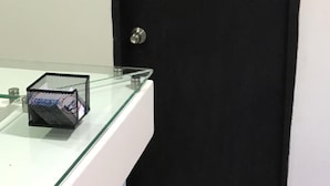 A black door with a sign reading "101" and a glass counter with a metal basket. - Barcelona Hotel (Montería)