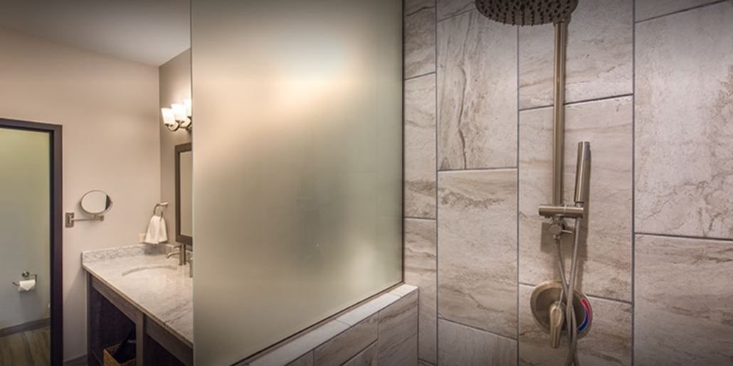 A modern bathroom with a shower, a vanity, and a mirror.