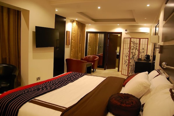 A hotel room with a bed, a TV, a desk, and a chair. - The Montrose Hotel Lekki (Lekki)