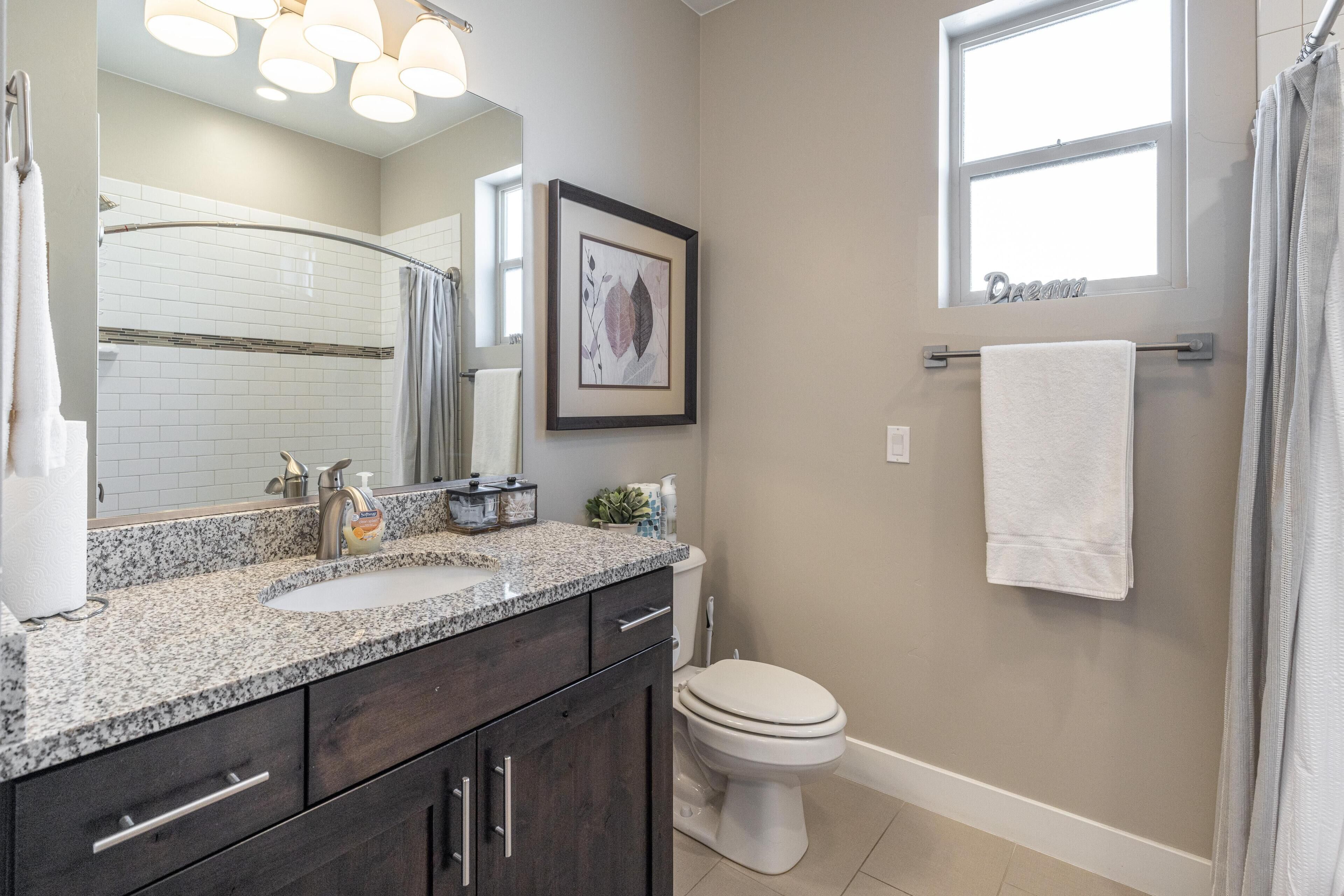 A bathroom with a sink, toilet, and shower.