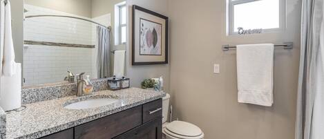 A bathroom with a sink, toilet, and shower.