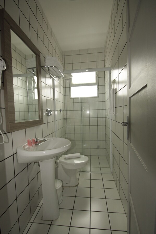Un baño pequeño con azulejos, un lavabo, un inodoro y un espejo.