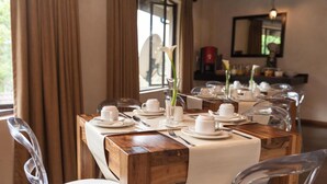 A dining area with tables set for four, each with white plates, cups, and cutlery. - The duBoirs Boutique Lodge (Waterfall)