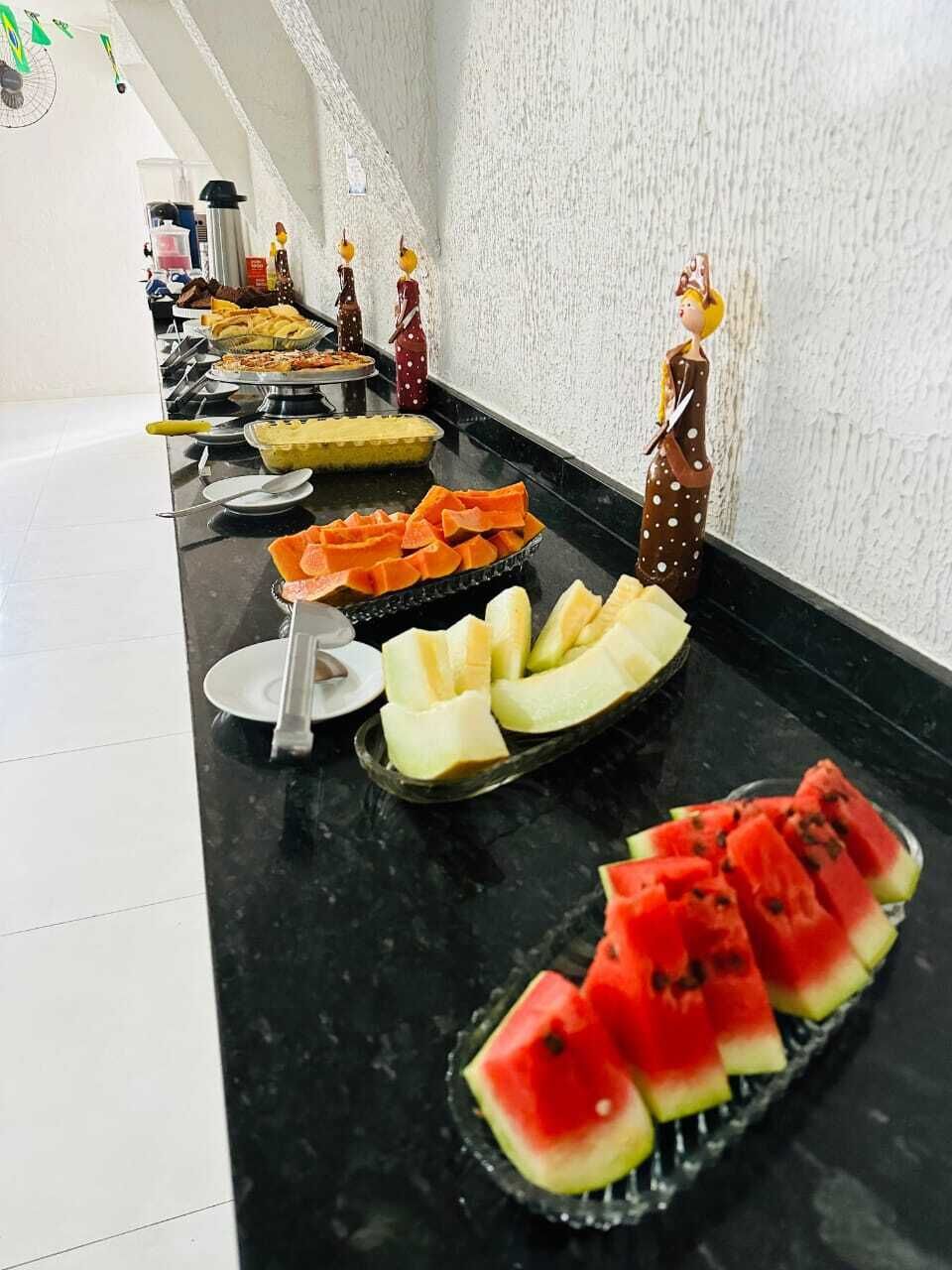 Ein reichhaltiges Buffet mit verschiedenen Speisen, darunter Wassermelone, Käse und Obst.