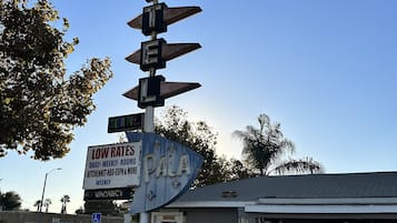 A motel sign with directional arrows and a 'No Vacancy' sign.
