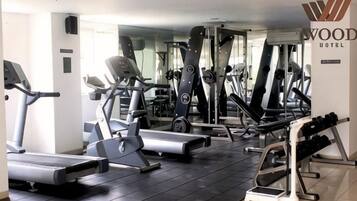 A hotel gym with treadmills, elliptical machines, and weight equipment.