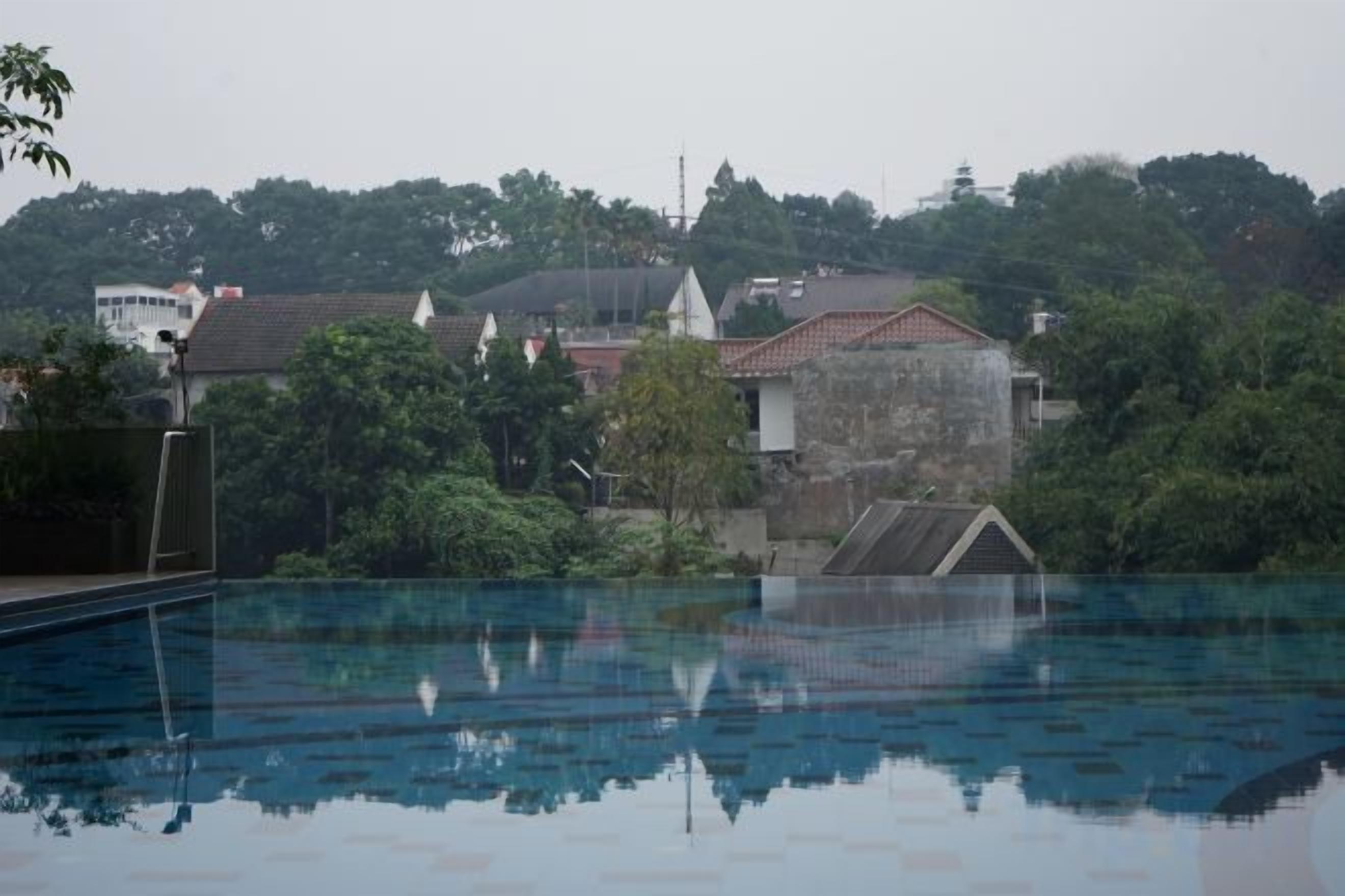 Piscina al aire libre con vista a edificios residenciales y árboles.
