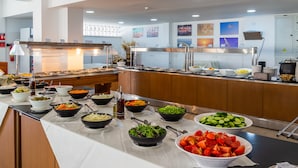 A buffet with various food items and a modern kitchen area in the background. - Tetyk Hotel  (Paralimni)