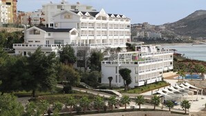 A multi-story hotel with balconies, a pool area, and a view of the sea. - Santa Quaranta Premium Resort (Sarandë)