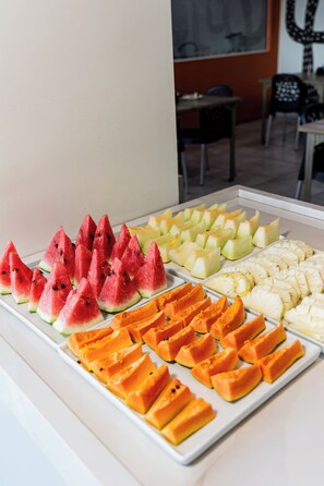 A fruit display with various types of sliced fruits arranged on a tray.