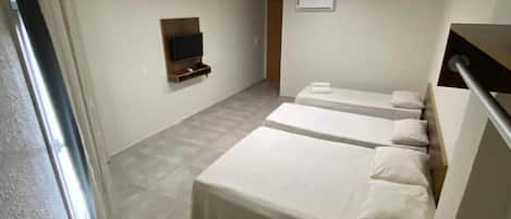 Una habitación de hotel moderna con una cama grande, un televisor montado en la pared y un escritorio con una silla.