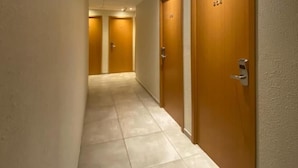 Un couloir avec des portes numérotées 224 et 225, qui donnent accès à des pièces.