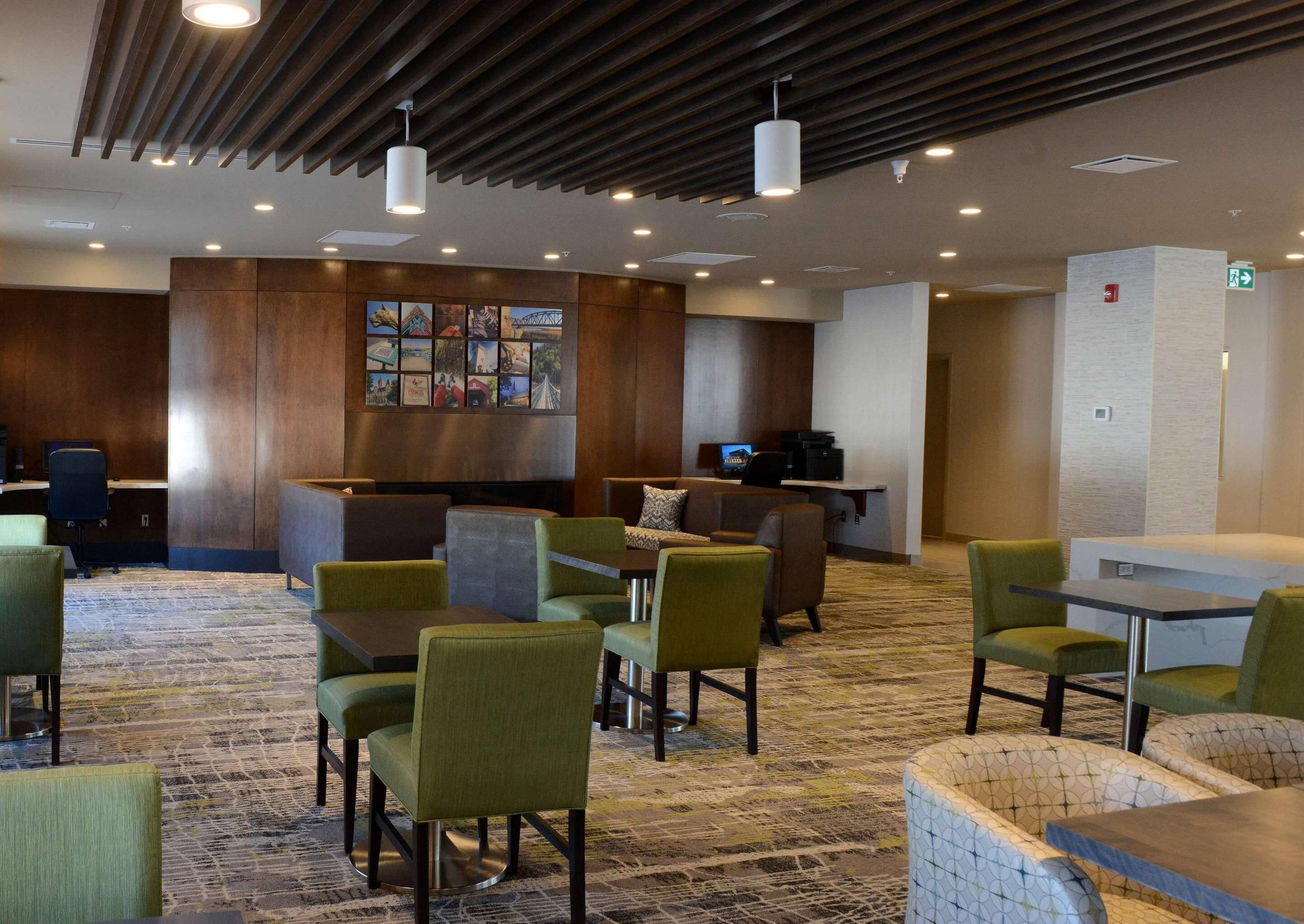 Et hotel lobby med reception, siddeområde og et tæppe på gulvet.