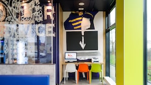 A modern workspace with a computer, chairs, and a large window. - Ibis Budget Bamberg (Bamberg)