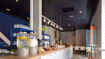 A modern cafe interior with a wooden counter, white cabinets, and a blue shelving unit.
