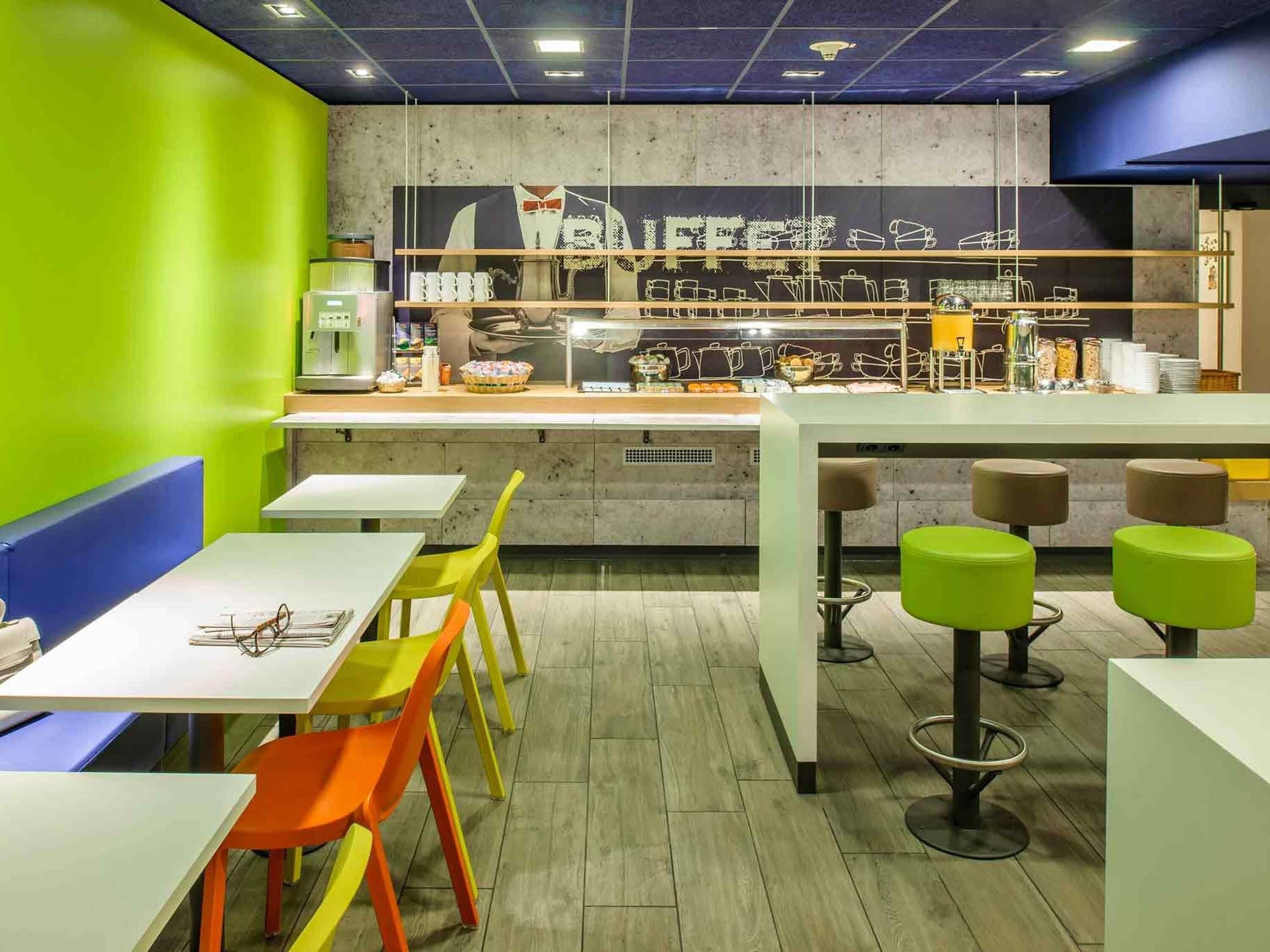 Un café avec un comptoir, des chaises et des tables.