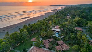 A resort with a beach view, multiple pools, and lush greenery.