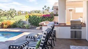 A patio with outdoor seating, a pool, and a barbecue area. - Desert Oasis on PGA WEST Palmer Private - #100182 3BR (La Quinta)