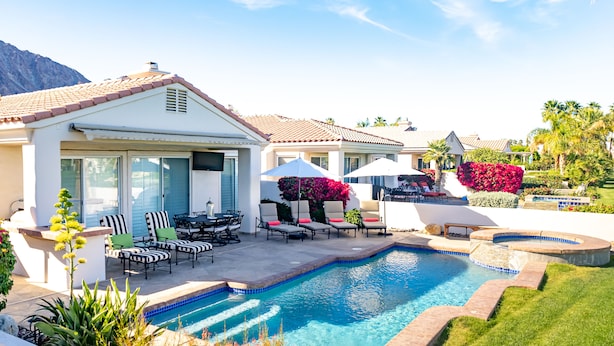 A residential property with a swimming pool, outdoor seating, and a well-maintained garden. - Desert Oasis on PGA WEST Palmer Private - #100182 3BR (La Quinta)