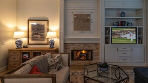 A living room with a fireplace, a television, and a coffee table. - Desert Oasis on PGA WEST Palmer Private - #100182 3BR (La Quinta)
