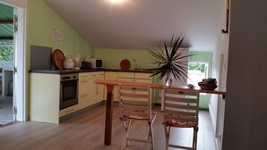 Une cuisine équipée d’une table et de chaises, d’un four à micro-ondes et d’un évier.