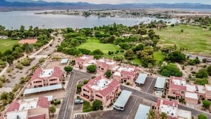 An aerial view of a residential area with multiple buildings, roads, and a large body of water in the background.