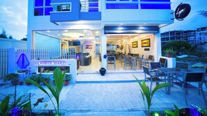 A modern building with a sign reading 'WHITE HART' and outdoor seating area. - The White Harp Beach Hotel (Hulhumalé)