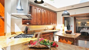 Une cuisine moderne avec des meubles en bois, une cuisinière à gaz et un puits de lumière.