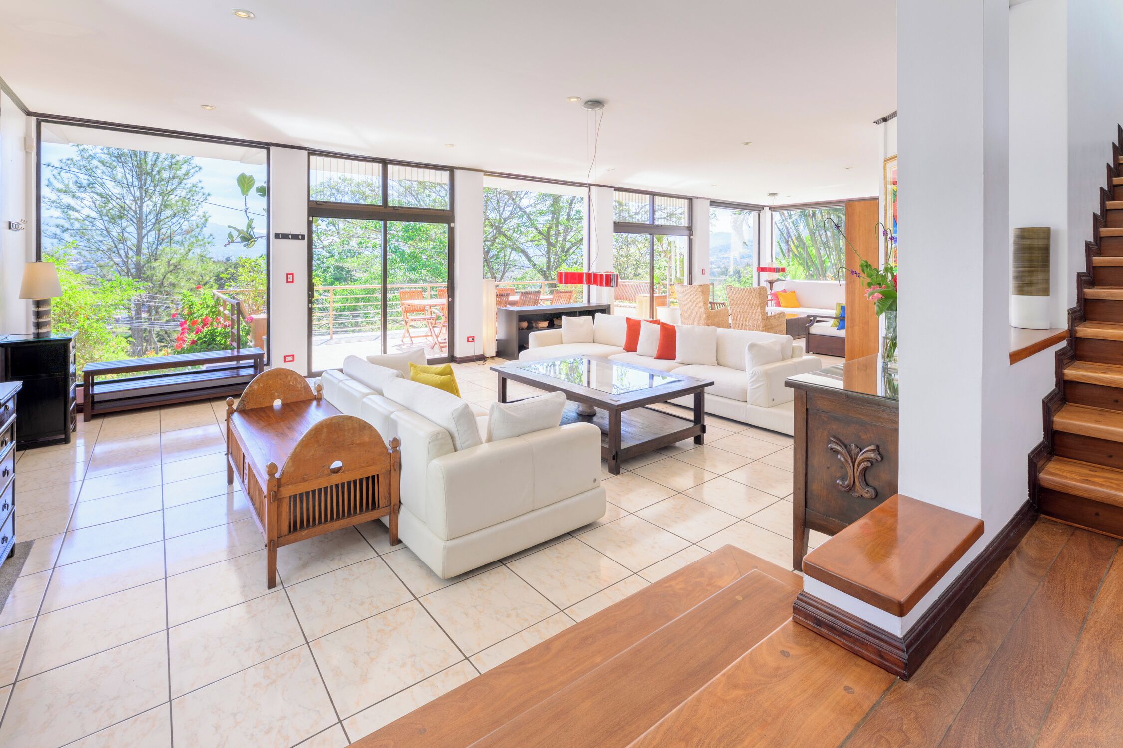 A spacious living area with a sofa, coffee table, and a staircase.