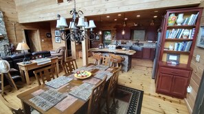 A spacious cabin interior with a dining area, kitchen, and living room. - Luxury Outdoor LR & BBQ, Mtn Top retreat- MOOSEMAC - 7 person hot tub & more!! (Morganton)
