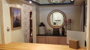 Un baño con tocador de madera, un espejo grande y un perchero para toallas.