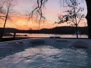 A hot tub with a view of a sunset over a lake, surrounded by trees. - Island View Hideaway- Peaceful, On the Water, Scenic, Birds, Nature, Sandbars! (Poynette)