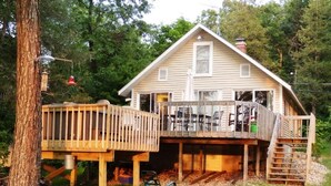 Une maison à deux étages dotée d’une terrasse et d’un espace extérieur abrité.